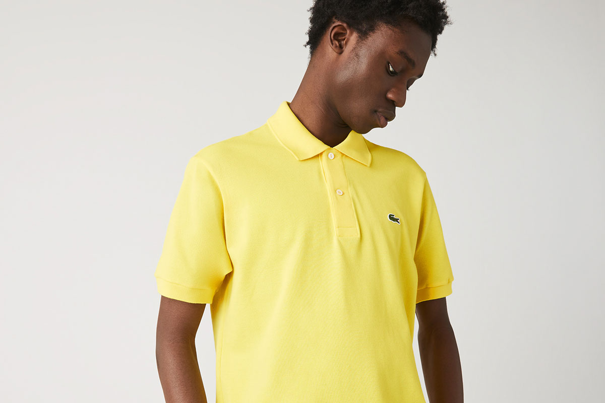 Lacoste Classic Fit Polo Shirt in yellow on male looking down.