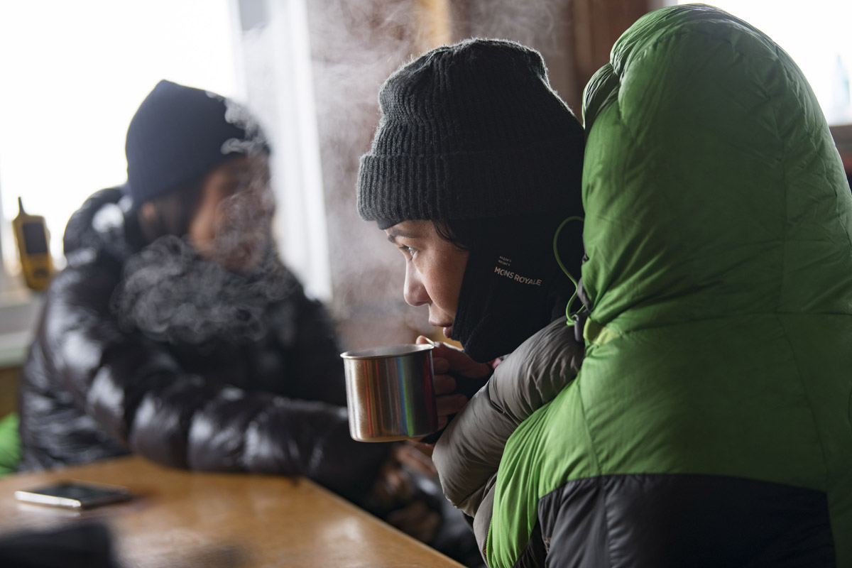 Janina keeping warm in Kelman Hut, photo by Mark Watson